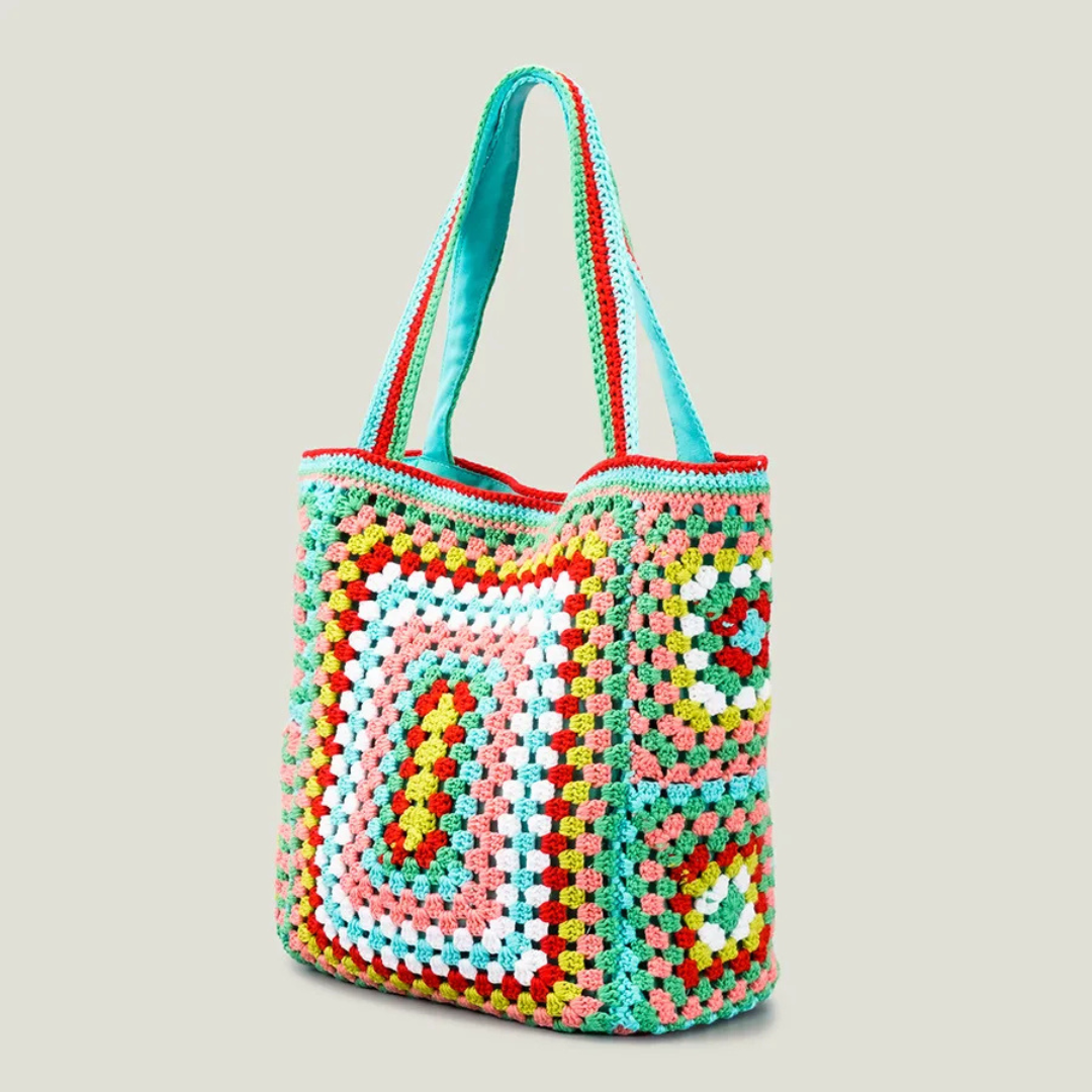 Green crocheted bag with a geometric pattern on a light gray background