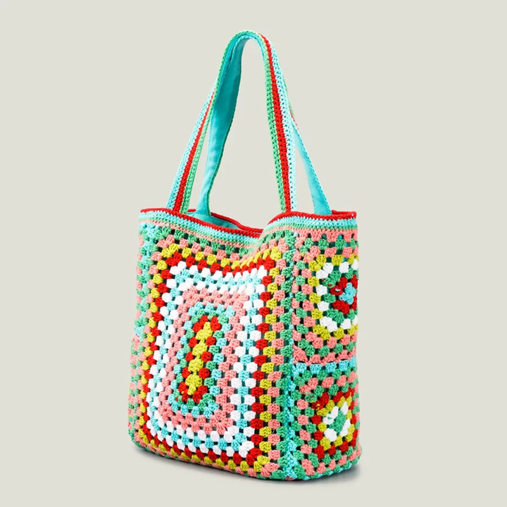 Green crocheted bag with a geometric pattern on a light gray background