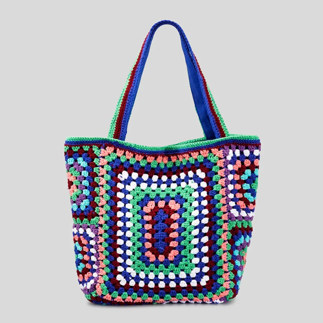 Blue crocheted bag with a geometric pattern on a gray background