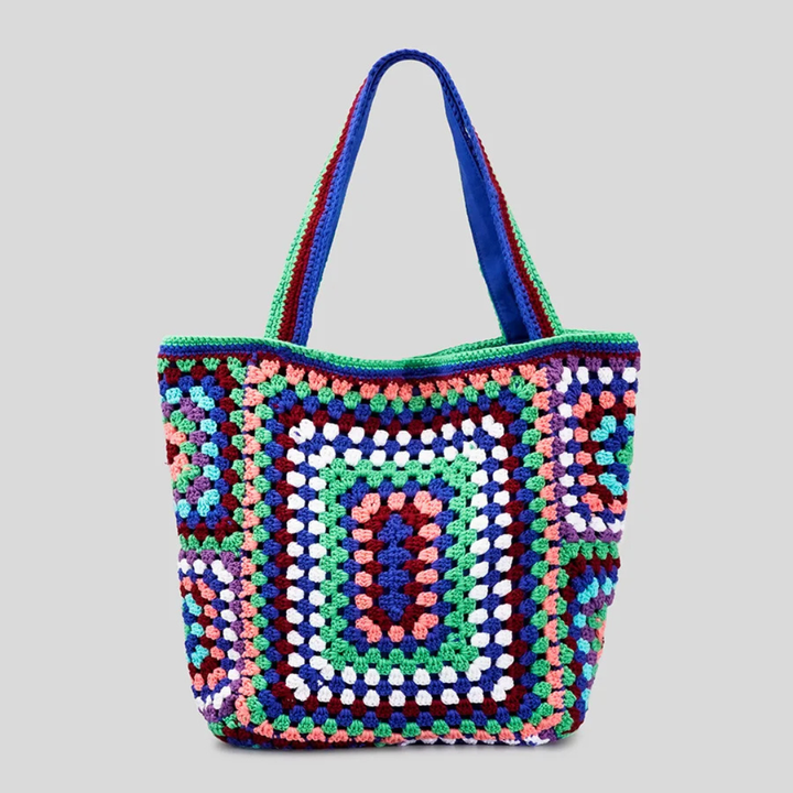 Blue crocheted bag with a geometric pattern on a gray background