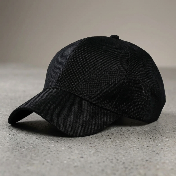 Black baseball cap on a gray surface with a neutral background