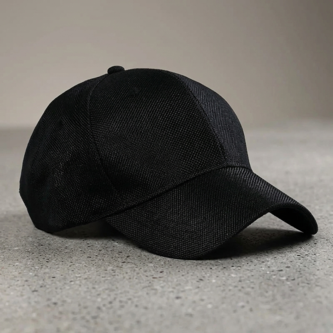 Black baseball cap on a gray surface with a neutral background