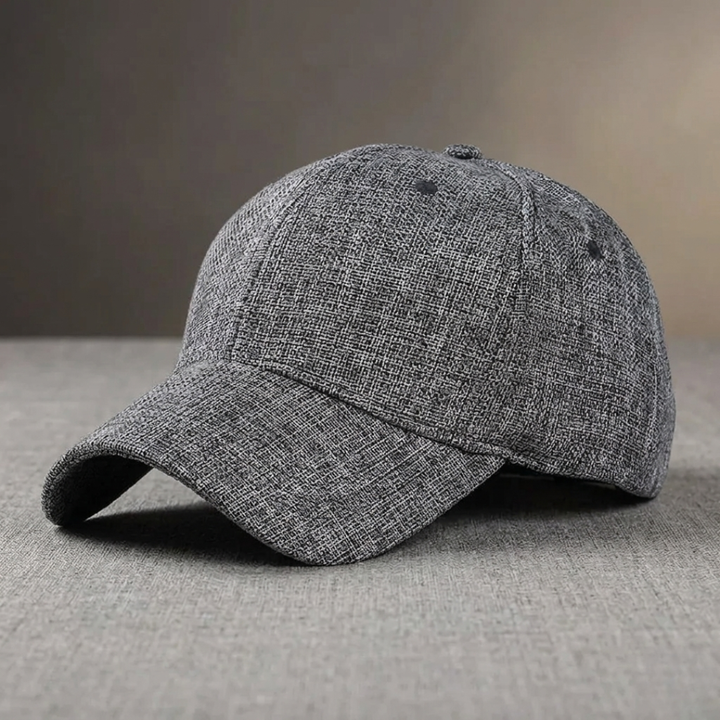 Gray baseball cap on a gray surface with a neutral background