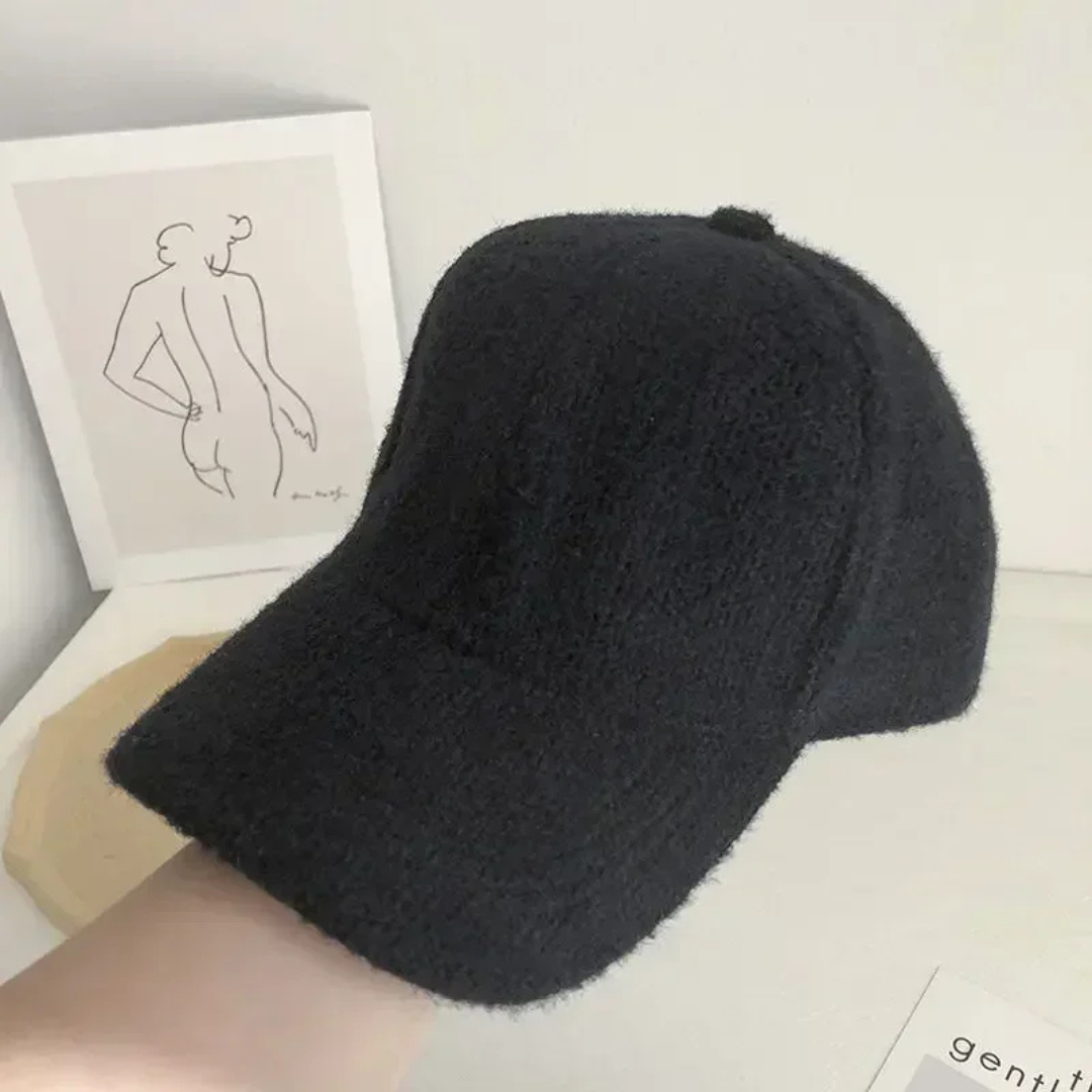 Black knitted beanie on a person's head with a minimal background