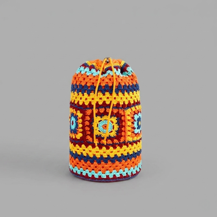 Orange crocheted bag with geometric pattern on a gray background