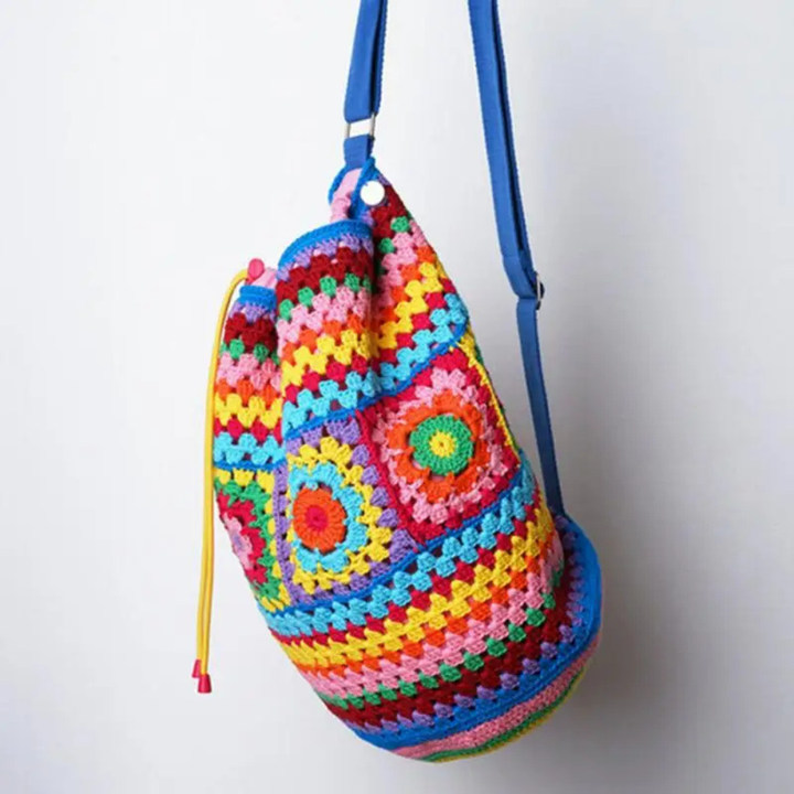 Colorful crocheted bag with a blue strap on a white background