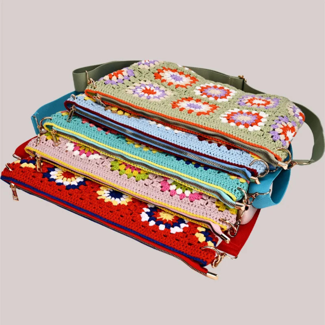 Stack of colorful crochet bags with floral patterns on a light gray background