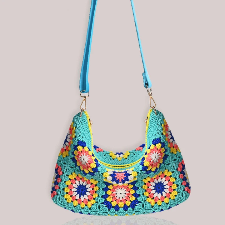Colorful crocheted handbag with a pattern on a light gray background