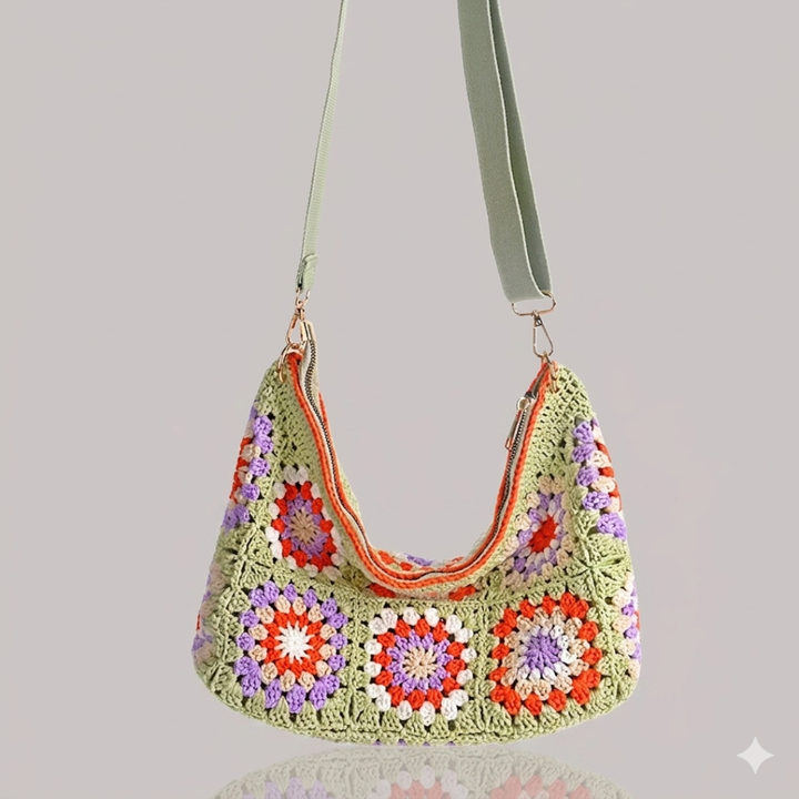 Crocheted handbag with light green strap patterns on a gray background
