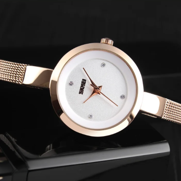 Rose gold watch with white face on a black background