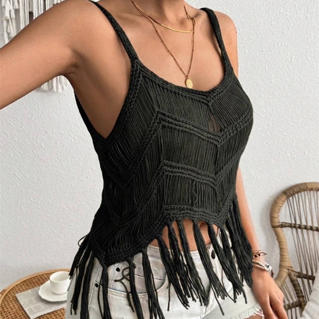 Black macrame tank top with fringe details worn by a person indoors.