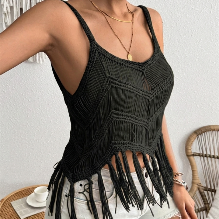 Black macrame tank top with fringe details worn by a person indoors.