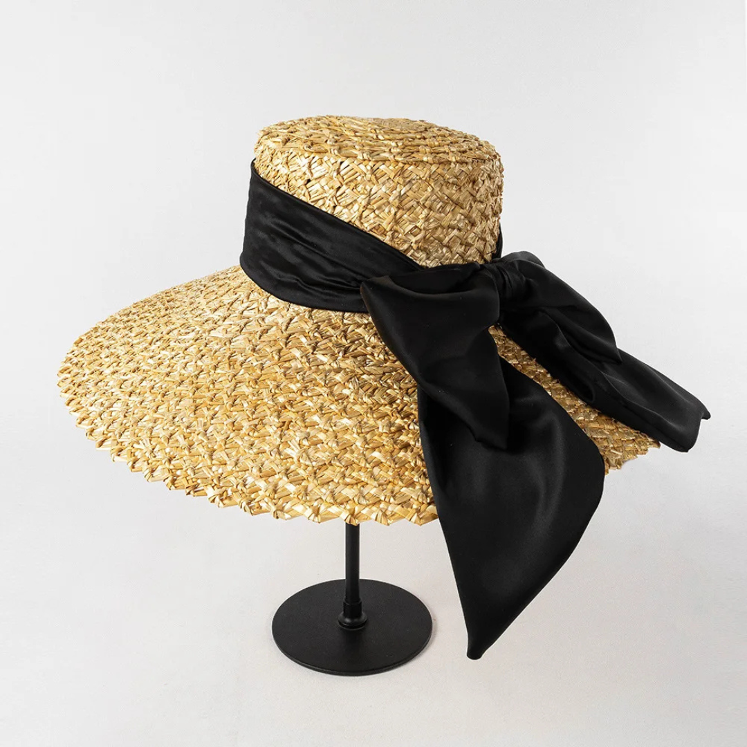 Straw hat with a black ribbon on a white background