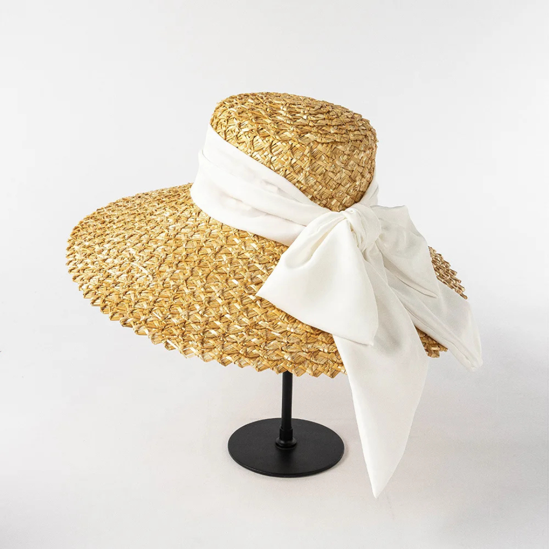 Straw hat with a white ribbon on a white background