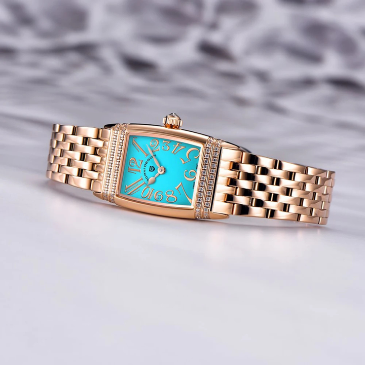 Gold watch with blue face on a light gray background