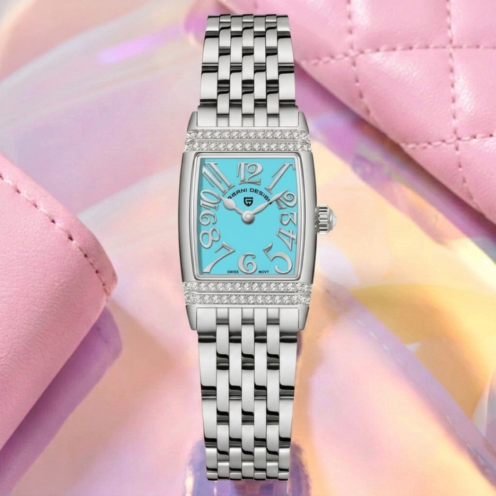 Silver watch with a blue face on a pink and yellow gradient background