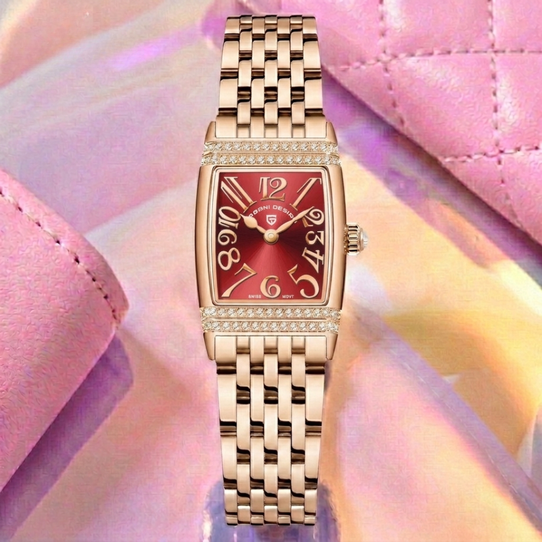 Gold wristwatch with a red face on a pink textured background