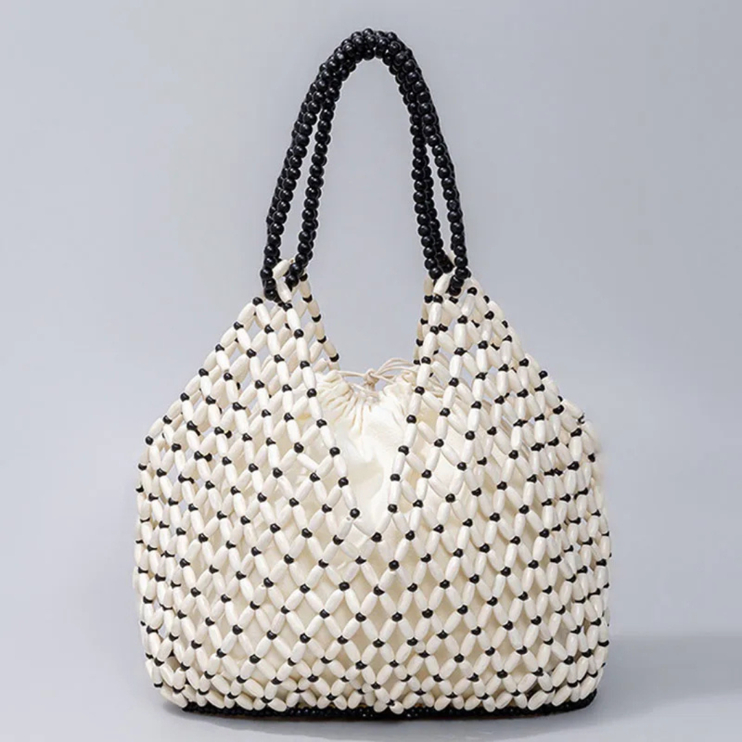 White woven bag with black accents on a gray background