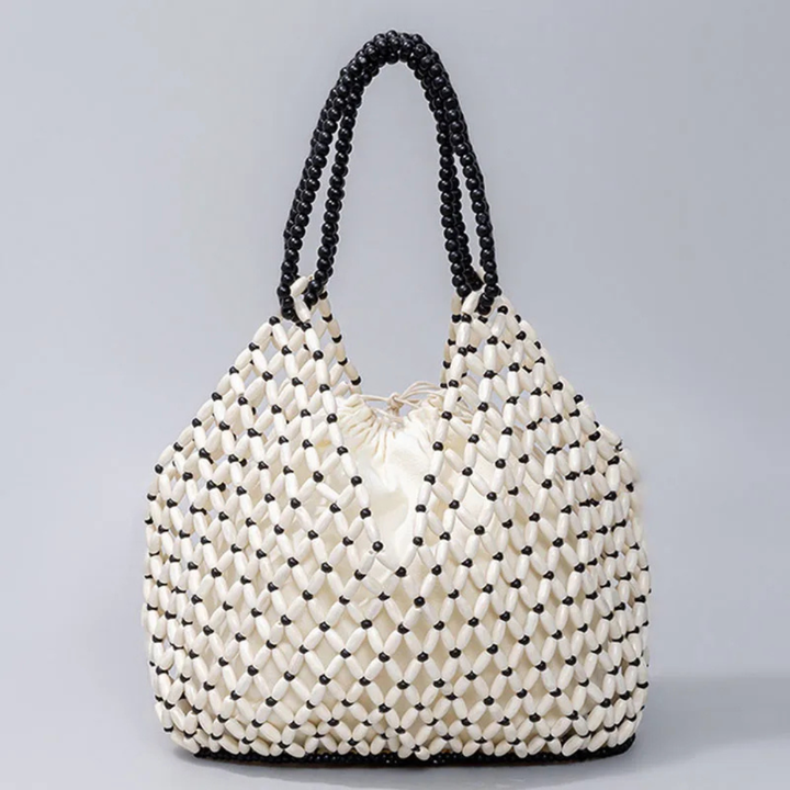 White woven bag with black accents on a gray background