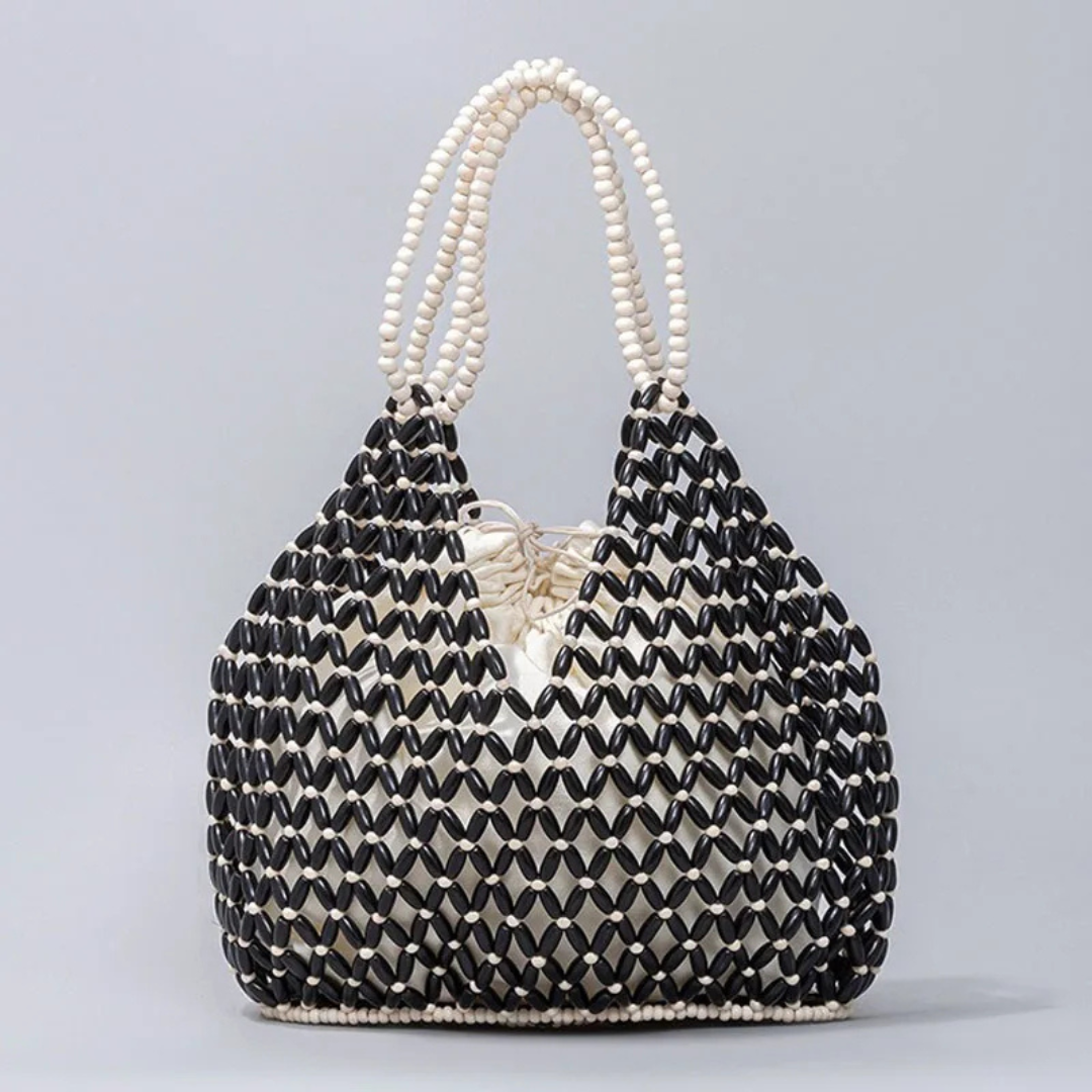 Beaded handbag with black and white pattern on a gray background