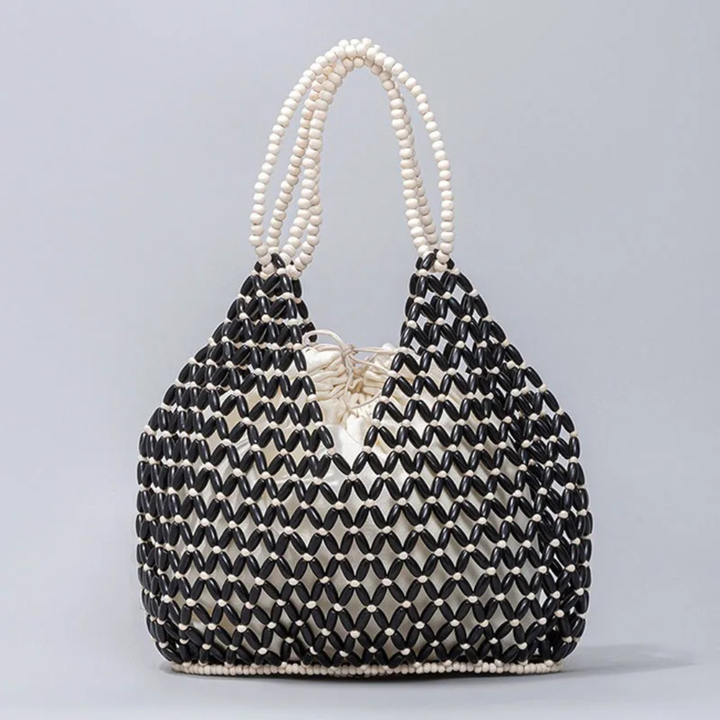 Beaded handbag with black and white pattern on a gray background