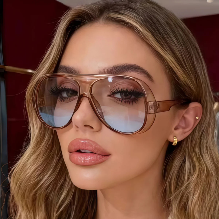 Woman wearing large Champagne sunglasses with a blurred background