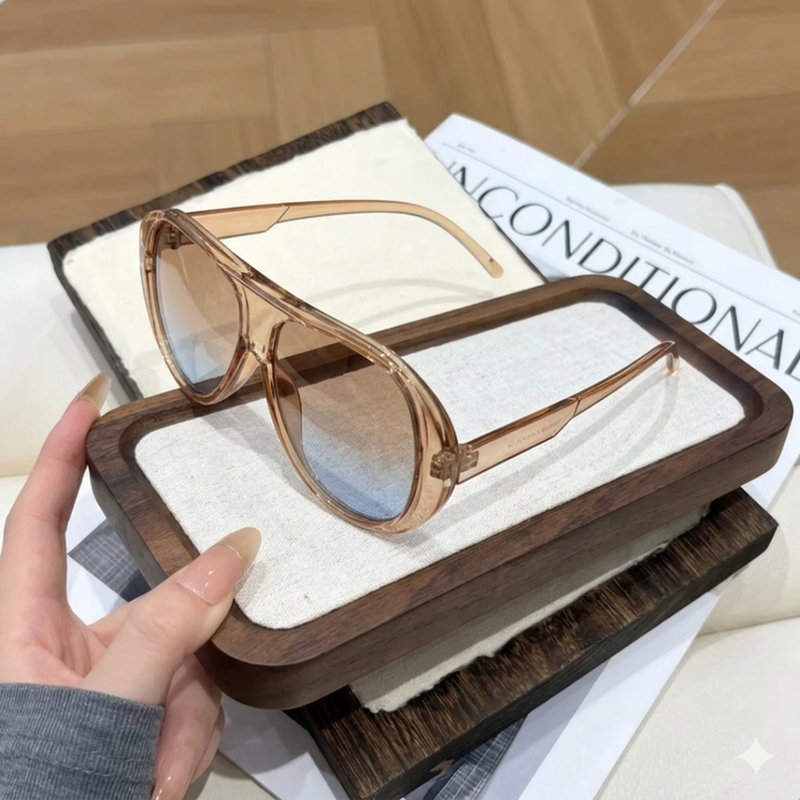 Champagne sunglasses in a wooden case held by a hand on a newspaper background