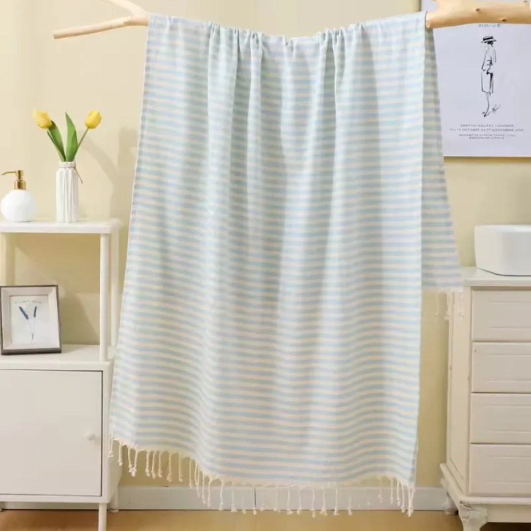 Light Green striped towel hanging in a room with furniture and decor.