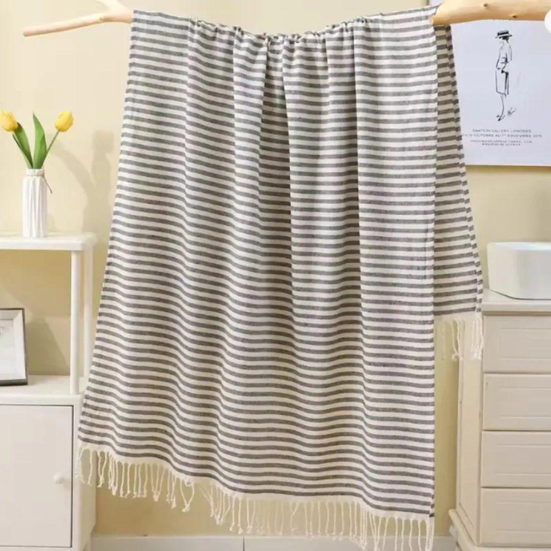 Striped gray towel hanging on a wooden rack in a bathroom setting.