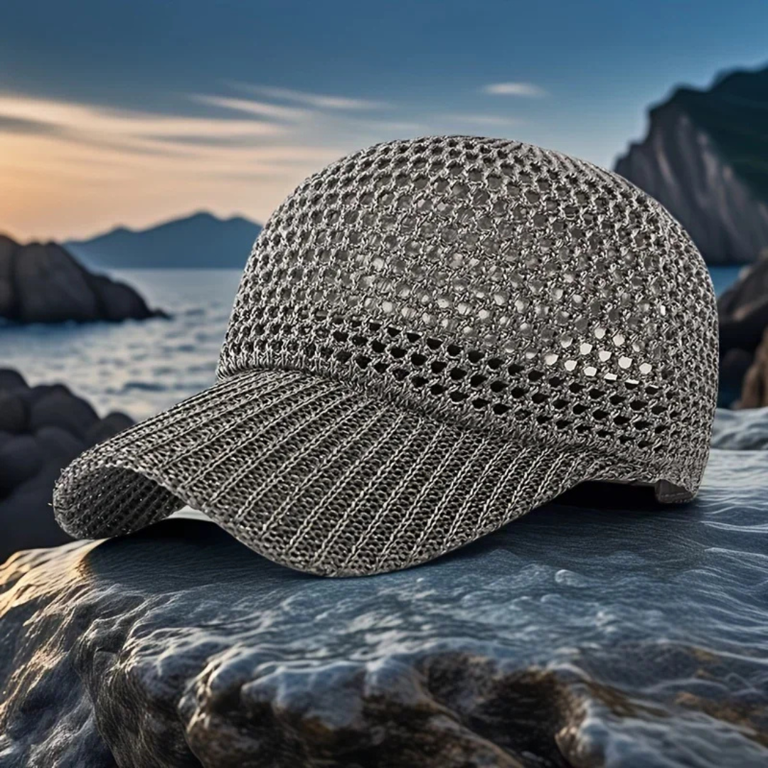 Gray cap on a rock with a scenic background of water and mountains.