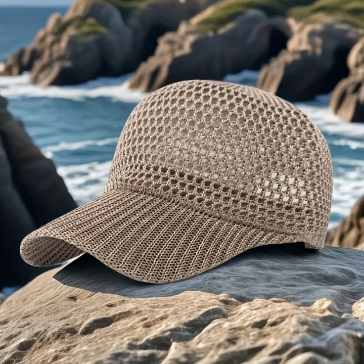 Khaki woven cap on a rock with ocean and rocks in the background