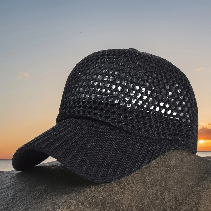 Black mesh cap on a rock with a sunset or sunrise in the background