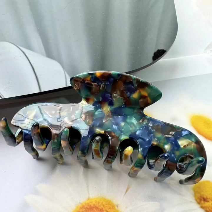 Floral hair clip on a white surface with flowers