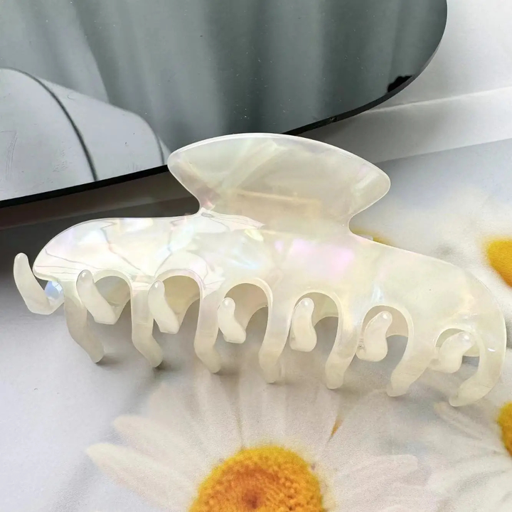 Jade hair clip on a white surface with a blurred background